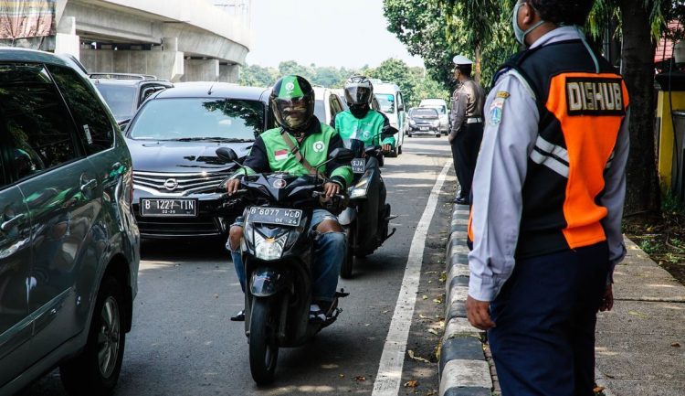 Pengendara ojek online melintasi salah satu ruas jalan di Jakarta. (Foto: voi.id).